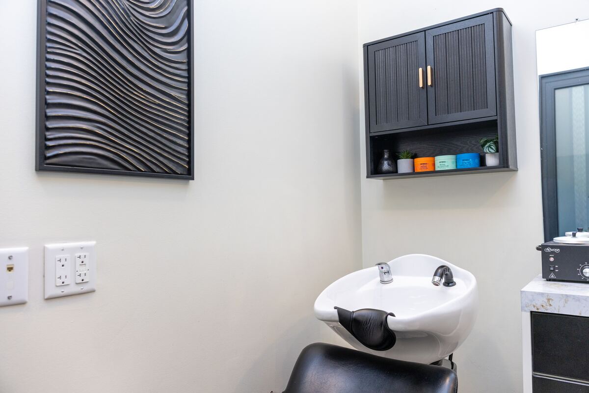 Interior of Three One Seven Hair Studio showing the styling station and shampoo basin